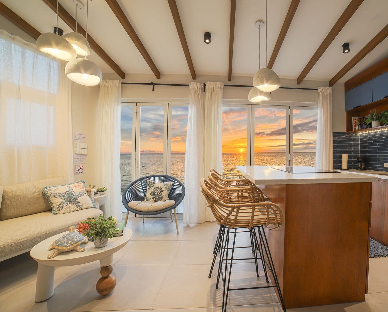 Delmare Rooftop living room with the sunset over the sea through the glass doors